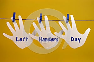 Left Handers Day message greeting across left hand silhouette cards hanging from pegs on a line