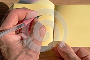 left male hand drawing on yellow blank paper note sticker