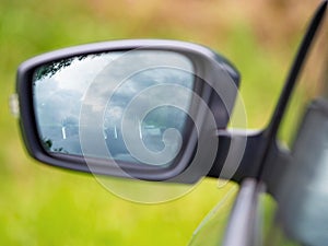 Left rear view mirror of the car with unclear view to driver seat