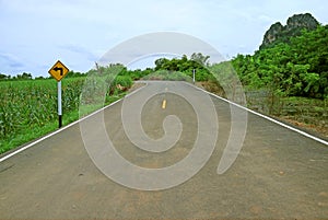 Left Turn Ahead Traffic Sign on the Country Roadside of Thailand
