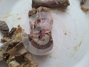 Leftover chicken bones in a white ceramic plate