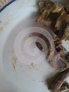 Leftover chicken bones in a white ceramic plate