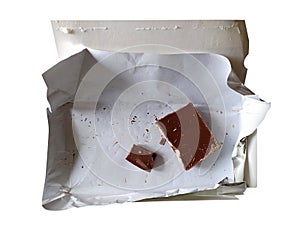 Leftover food, pieces of chocolate in the package. Junkfood on a diet. Cocoa tile isolated on white