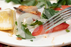 Leftovers on a plate close-up. Eat food with a knife and fork. Delicious lunch, vegetables, proper nutrition. Italian food. Useful