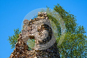 Leftovers of stone block building in summer green meadow