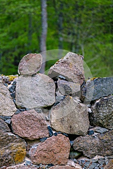 Leftovers of stone block building in summer green meadow