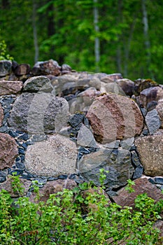 Leftovers of stone block building in summer green meadow