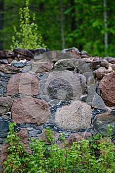 Leftovers of stone block building in summer green meadow