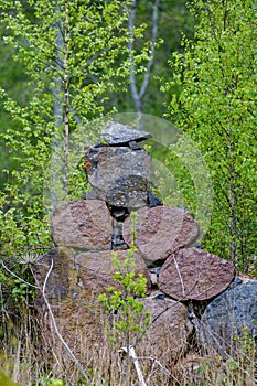 Leftovers of stone block building in summer green meadow