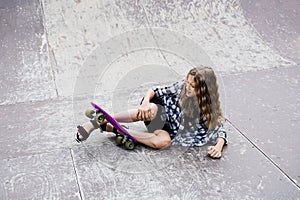 Leg and knee injury on penny board. Child traumatology. Child girl falling from skate board and get injured and feeling