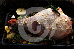 Raw Leg of lamb dressed with vegetables