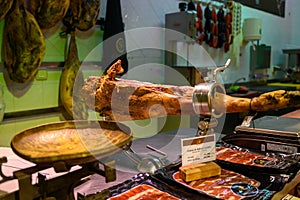 Leg of pork serrano Iberian cured jamon on stand in Spanish butcher\'s shop