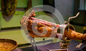 Leg of pork serrano Iberian cured jamon on stand in Spanish butcher\'s shop