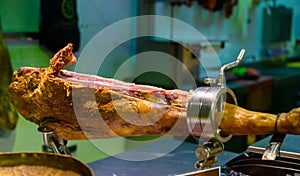 Leg of pork serrano Iberian cured jamon on stand in Spanish butcher\'s shop