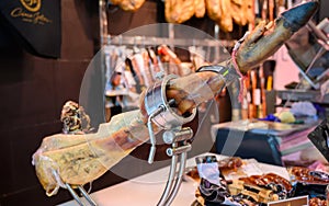 Leg of pork serrano Iberian cured jamon on stand in Spanish butcher\'s shop