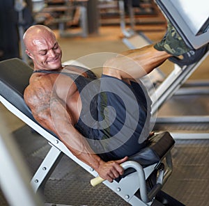 Leg press, man and fitness at gym with bodybuilder, cardio and muscle power at health club. Wellness, athlete and