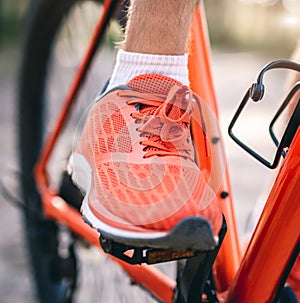 Leg in sneaker on bike pedal