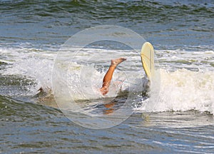 Leg sticking out of the water after a surfer falls of surboard while surfing