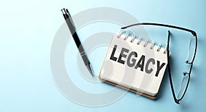 LEGACY text written on a notepad on the blue background