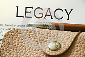 Legacy word, beige leather wallet and pen. Last will heritage statement wellfare concept