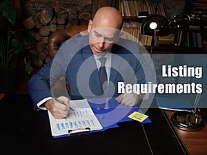 Legal concept about Listing Requirements Businessman, executive manager hand filling paper business document