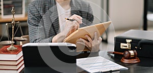 Legal counsel working with paperwork on his desk in office workplace working with tablet computer. Justice and law concept