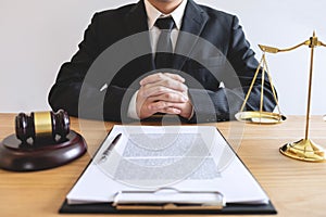 Legal law, advice and justice concept, male lawyer or notary working on a documents and report of the important case and wooden g