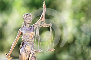 Legal law concept statue of Lady Justice with scales of justice with green background