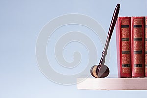 Legal Law and Justice concept - Open law book with a wooden judges gavel on table in a courtroom or law enforcement