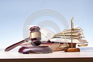 Legal Law and Justice concept - Open law book with a wooden judges gavel on table in a courtroom or law enforcement