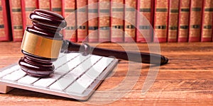 Legal Law and Justice concept - Open law book with a wooden judges gavel on table in a courtroom or law enforcement