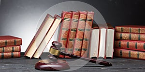 Legal Law and Justice concept - Open law book with a wooden judges gavel on table in a courtroom or law enforcement