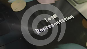 Legal Representation inscription on smartphone screen. Graphic presentation on black background with bokeh lights. Light