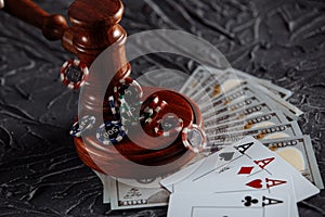 Legal rules for online gambling concept. Wooden gavel and playing cards on grey background
