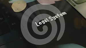 Legal System inscription on smartphone screen. Graphic presentation on black background with bokeh lights. Light rays