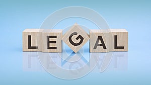 LEGAL - word is written on wooden cubes on a bright blue background. close-up of wooden elements