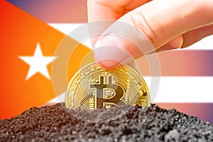 Legalization of bitcoins in Cuba. Bitcoin landing in the ground against the background of the flag of Cuba. Cuba -