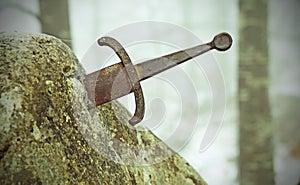 legendary Excalibur sword into the stone in the middle of the forest