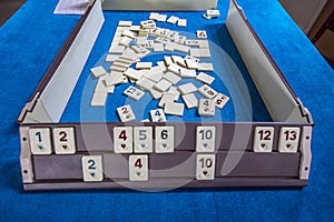 Legendary game okey and game table. Turkish board game Okey Rummikub. A table with green cloth and chips. Hands of the players