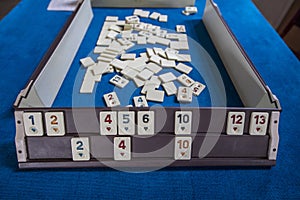 Legendary game okey and game table. Turkish board game Okey Rummikub. A table with green cloth and chips. Hands of the players