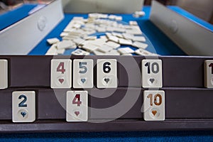 Legendary game okey and game table. Turkish board game Okey Rummikub. A table with green cloth and chips. Hands of the players