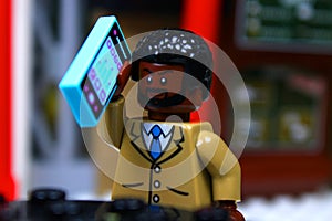 Lego mini-figure Guy making a phone call
