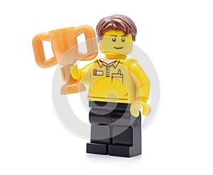 Lego minifigure in brand uniform hods a golden cup