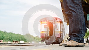 The legs of an adventurer wearing sneakers waiting for the train.Travel and adventure concept