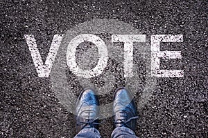 Legs on asphalt with the word `vote`