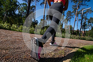 Legs of an athlete running along a park path. Outdoor sports