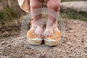 The legs of the baby stand on the feet of the mother, mom supports the little baby daughter.First steps. Mom teaches her