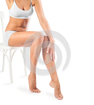 Legs of beautiful female sitting on chair