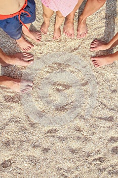 A Legs of the beautiful whole family on the sand near the sea background