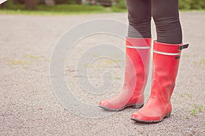 Legs below knees wearing red boots in Finnish nature. Traditional foot wear in Finland